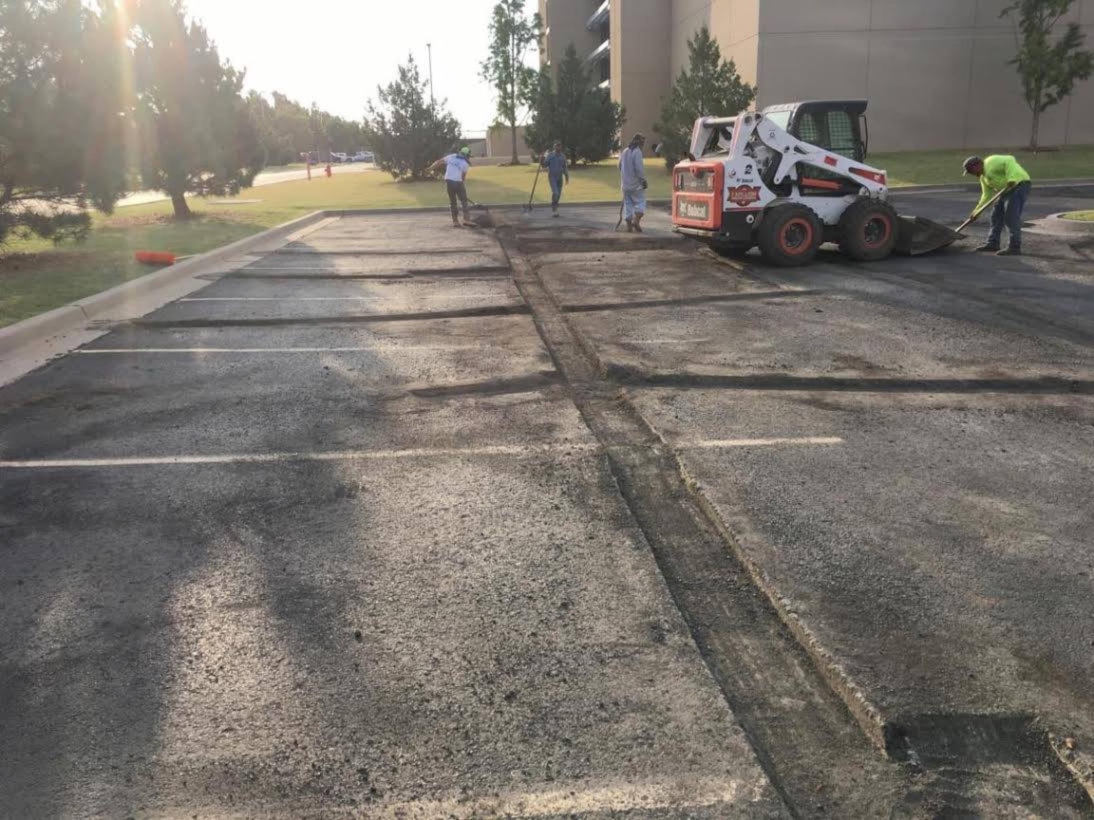 Skid steer milling a commercial parking lot for repair