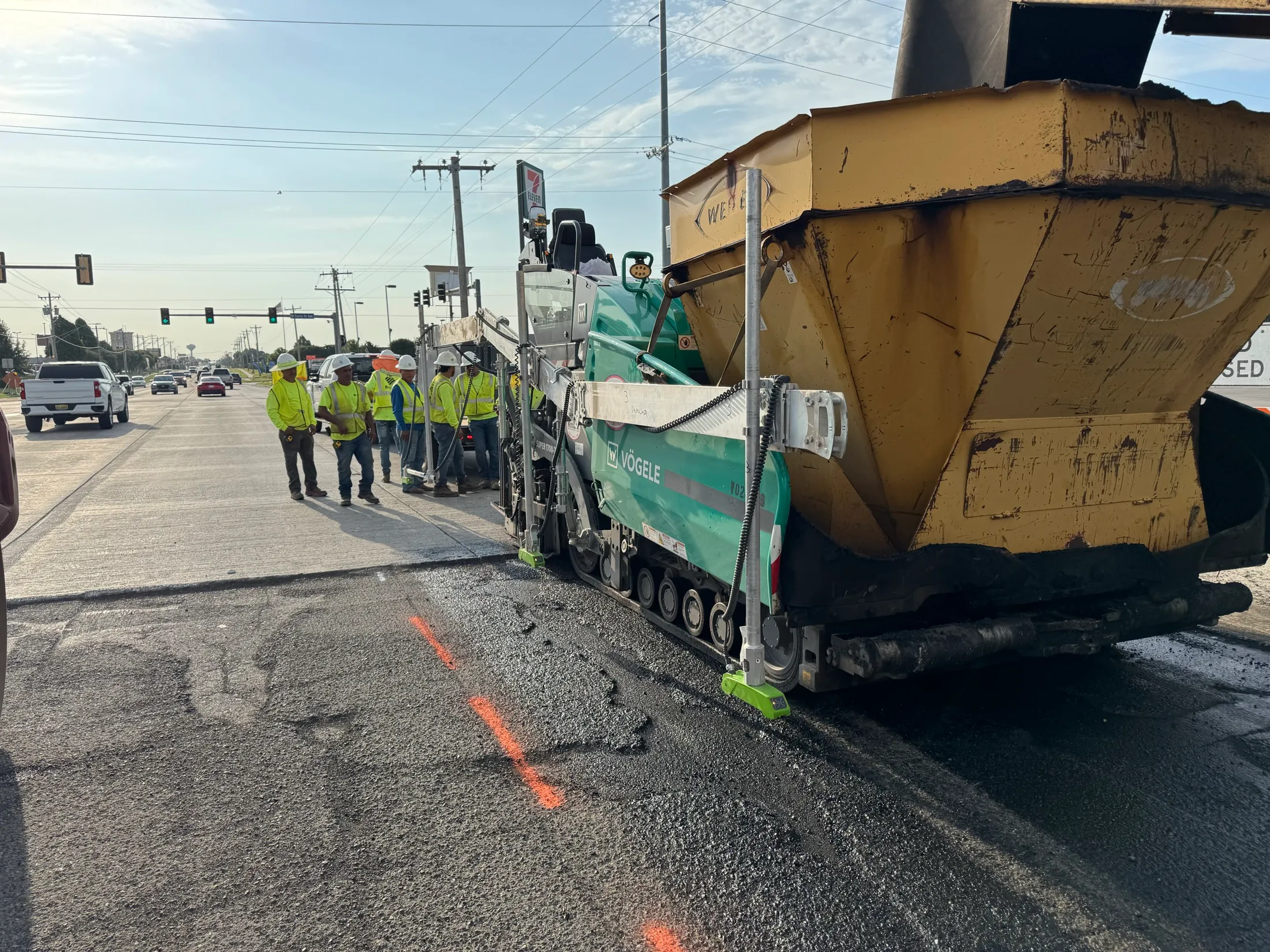 A First Water crew paving a commercial arterial behind the paver and material transfer machine