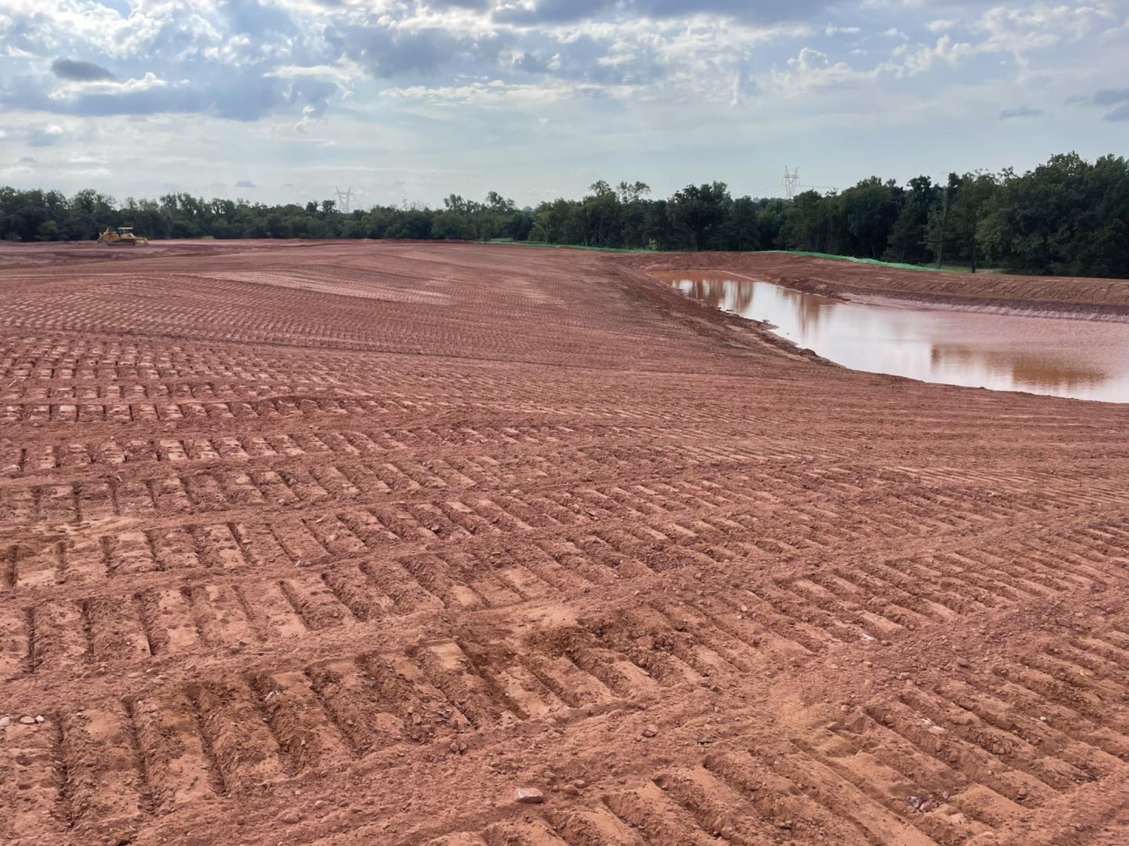 Crews shaping a detention pond during mass grading