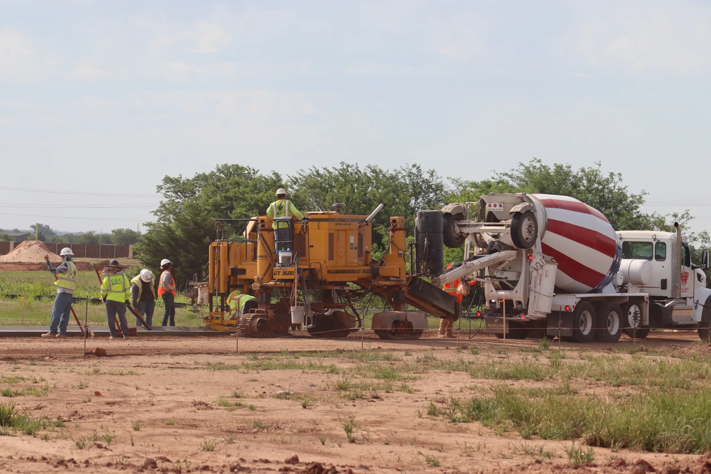 Concrete paving crew with slipform machine