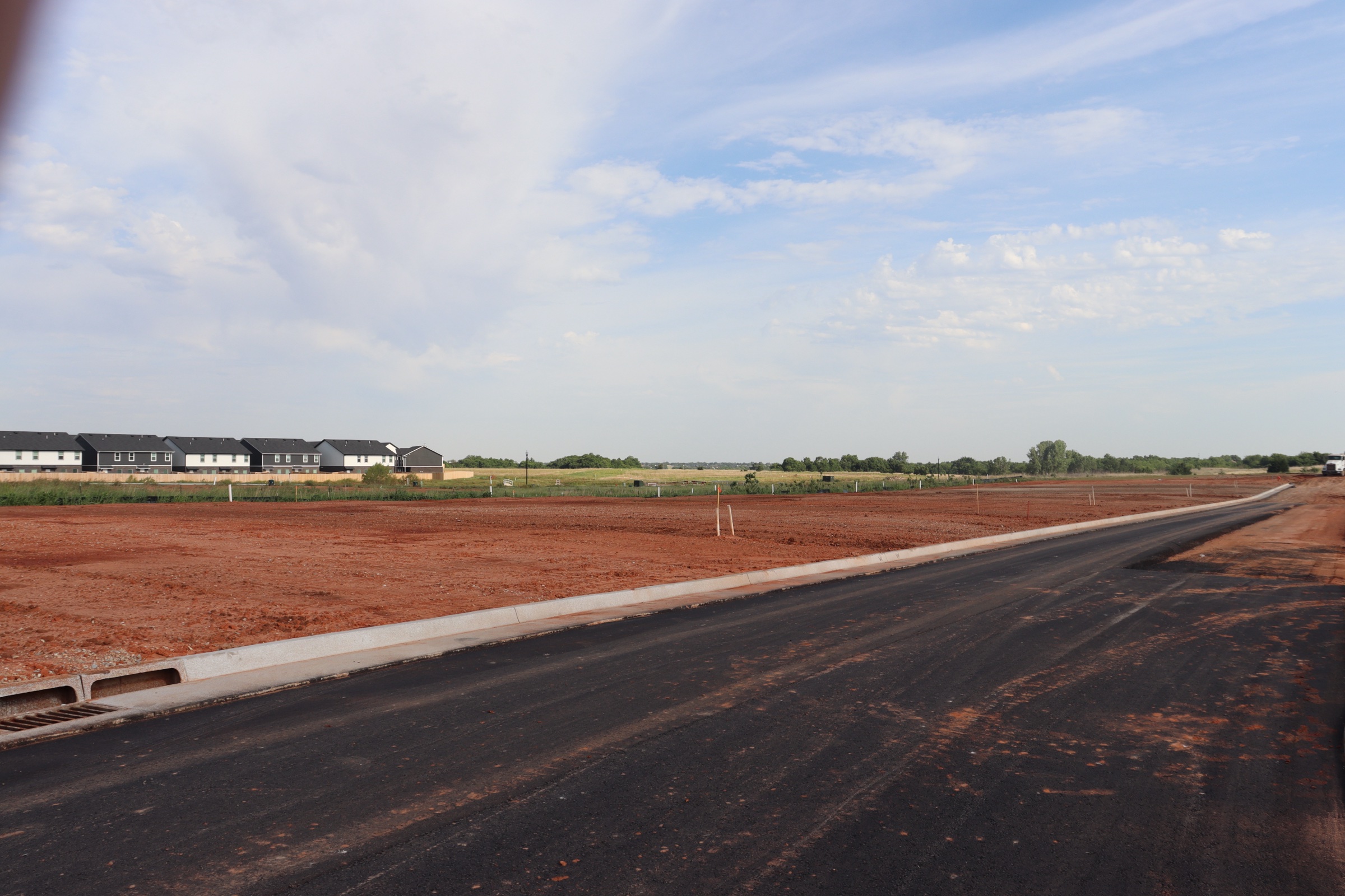 Finished asphalt street through a new Oklahoma subdivision